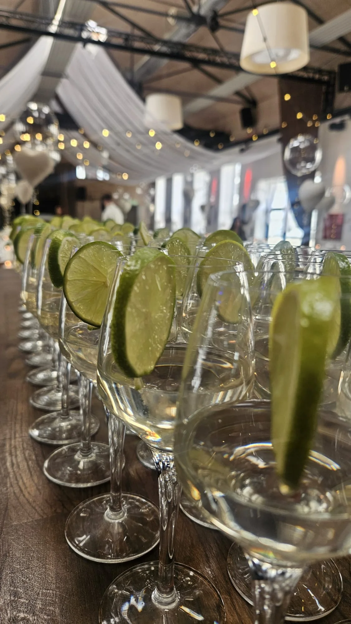 Velkomstdrinks med limeskiver i glas foran det opdækkede lokale